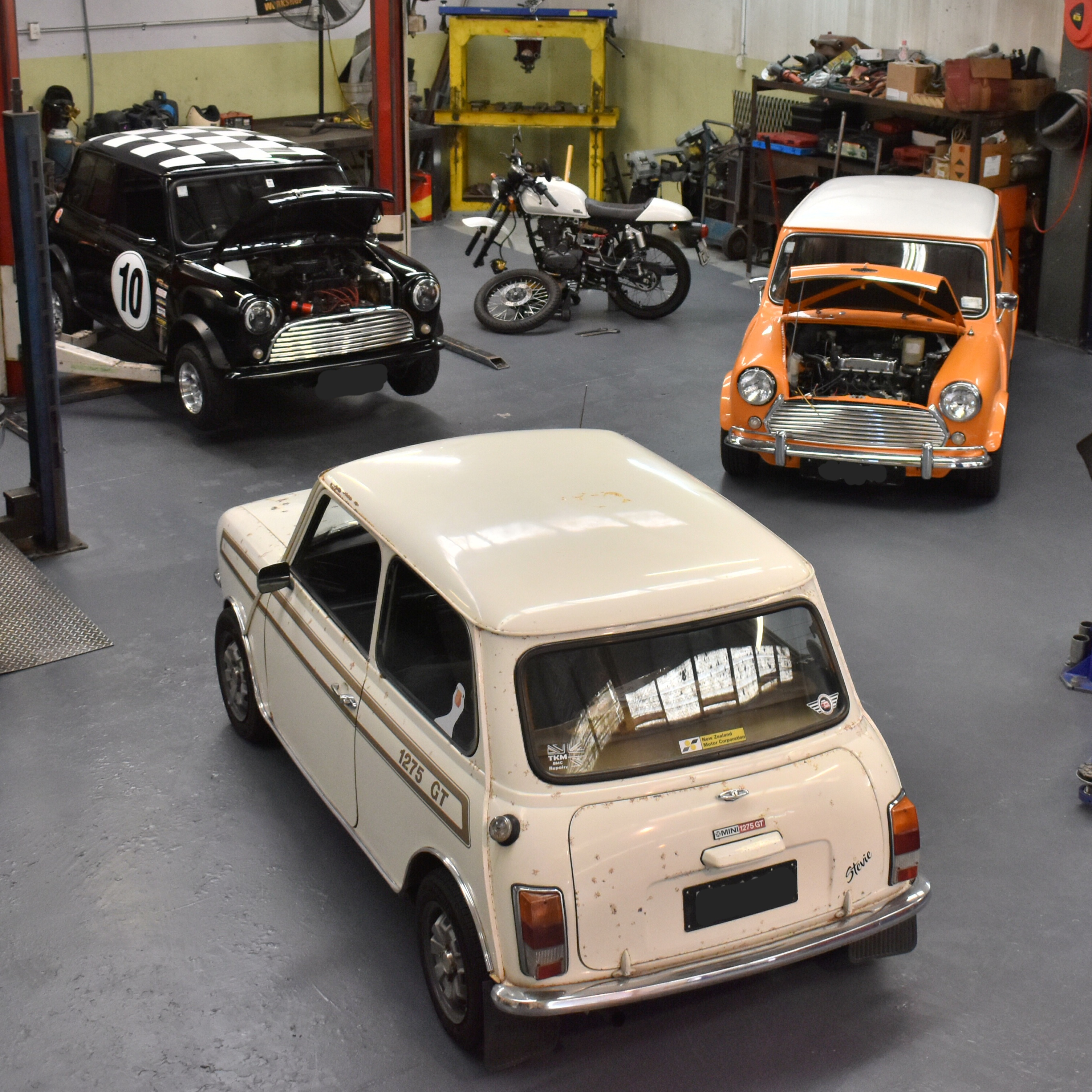 Classic Mini cars and a motorcycle inside the Hannah Motor Services workshop